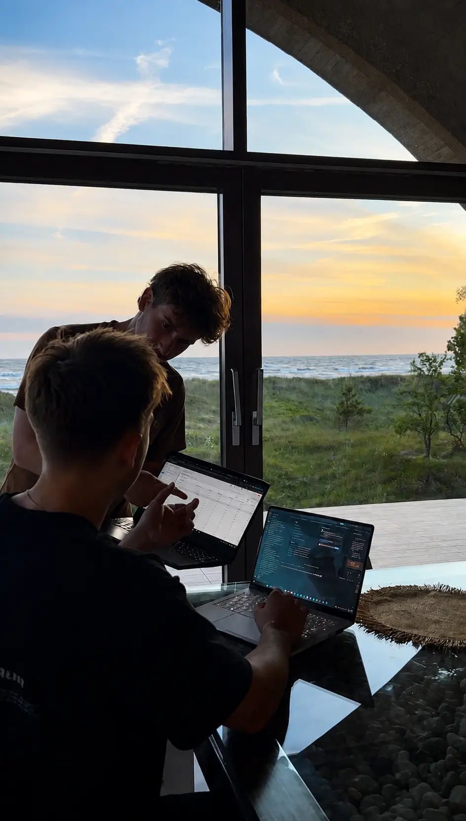 Two of the NorthVisible team reviewing campaign dashboards on laptops at sunset.
